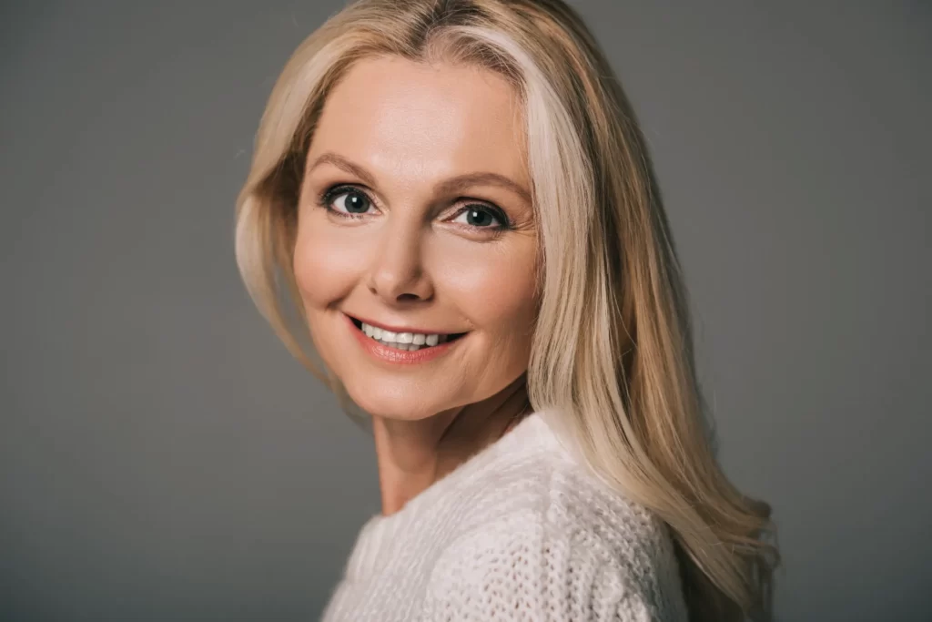 beautiful mature woman in white sweater isolated o utc