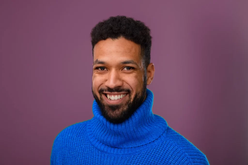portrait of happy multiracial man in knitted sweat utc